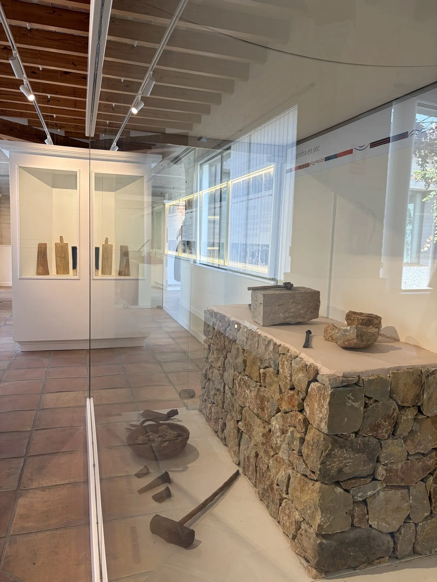 Display case "La pedra en sec" with a dry-stone wall and old stonemason's tools